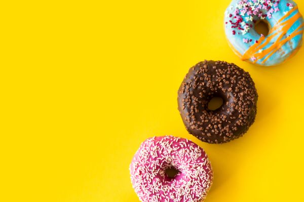 Yummy Donuts on Yellow Background Free Photo